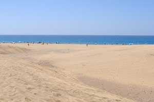 Maspalomas beach is a huge beach that you can see for miles, with high sand dunes beside