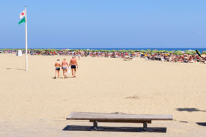 A wooden bench is on Maspalomas beach