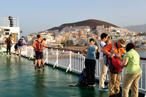 Tourists photograph Los Cristianos early in the morning from the upper deck of Volcán de Taburiente ferry