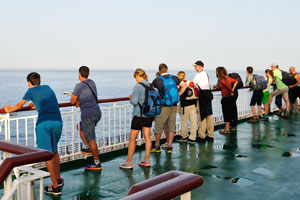 Tourists watch the ocean early in the morning from the upper deck of Volcán de Taburiente ferry