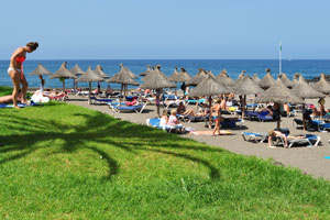 The soft green grass is a wonderful place for the rest on Playa de El Bobo beach