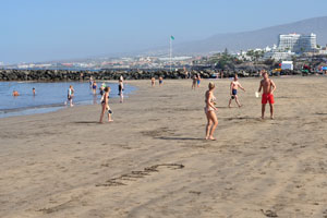 Tourists are playing badminton on Playa de Troya beach