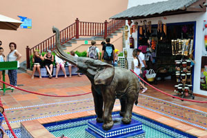 A small elephant statue is located in the midst of souvenir shops