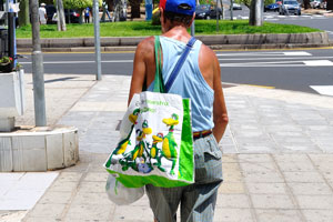 A man with a HiperDino bag is walking along Avenida de Ámsterdam