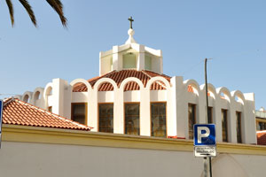 A cross rises above Nuestra Señora del Carmen church