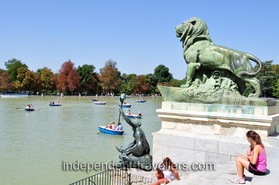 Stone statue of a lion overlooking Estanque Grande del Retiro pond