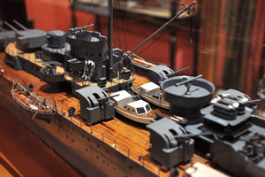 This is a model of a cruiser with cannons and motorboats on its deck
