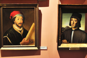 The portrait of Juan de la Cosa “1449-1509” is on the left and the portrait of Martín Alonso Pinzón “1441-1493” is on the right