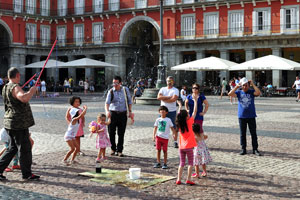 A man is blowing giant soap bubbles on Plaza Mayor
