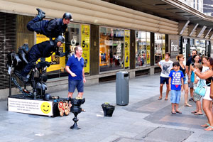 A man wants to be photographed with street performers on Calle de Preciados street