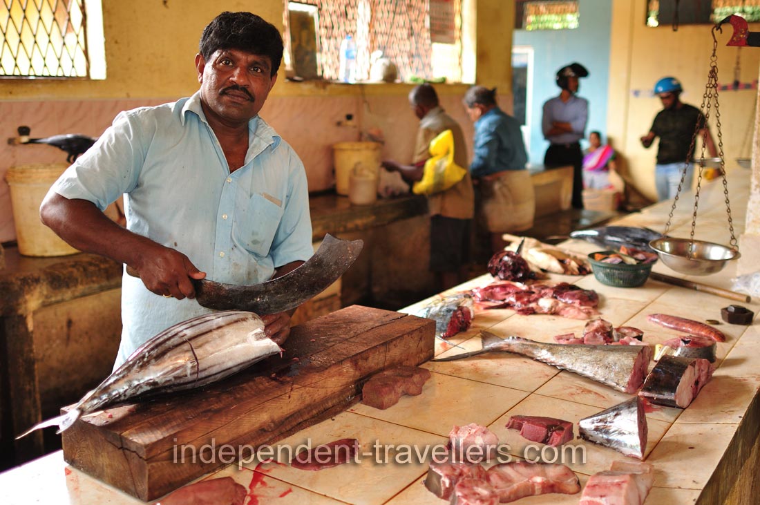 A male fish vendor cuts tuna