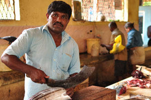 A male fish vendor cuts tuna