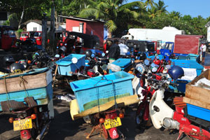 Motorcycles are in the parking place of fishing harbour