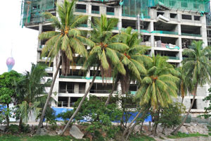 Coconut palms grow beside the Destiny Mall & Residency apartment complex