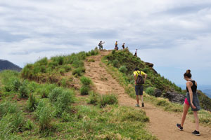 Tourists walk along the footpath at the top of the peak