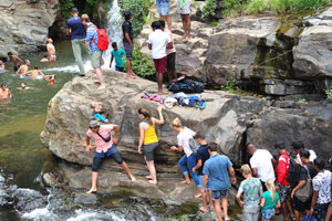 Ravana Falls gushes down a rock face, creating rock pools along its path