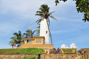 The Galle Lighthouse is hidden behind a palm tree