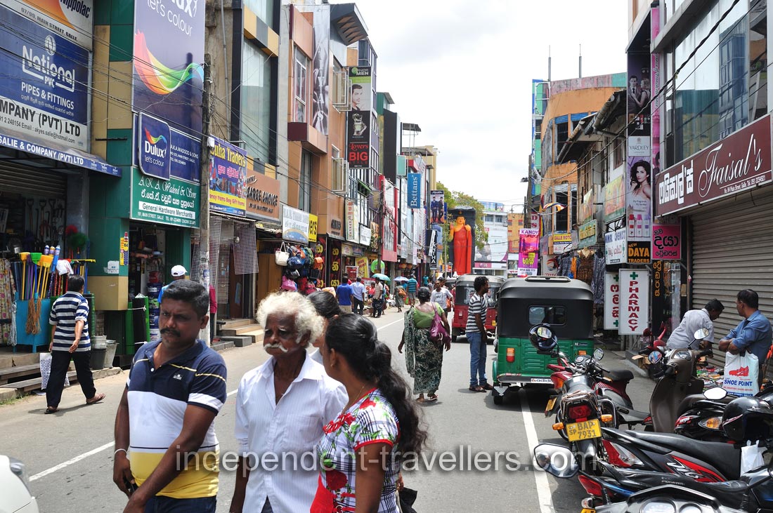An elderly man walks along Main street with family
