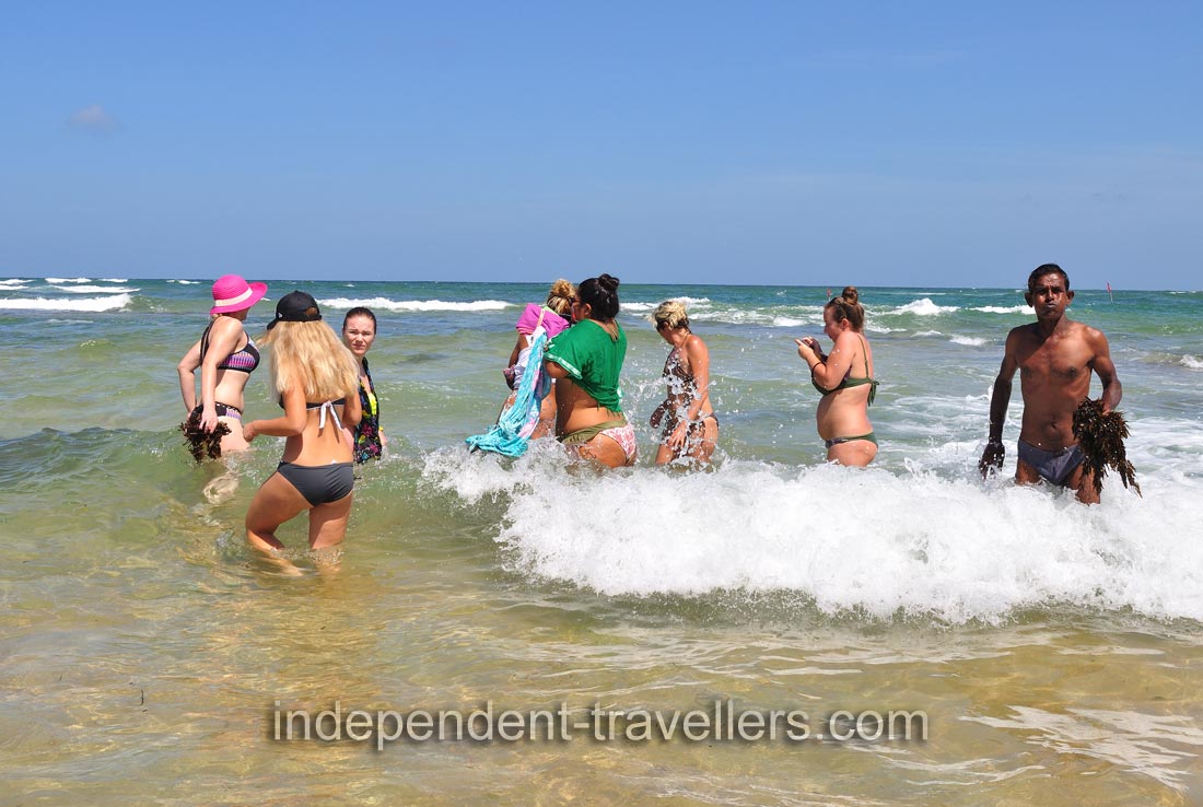 Women even do not afraid the waves because their wish to feed sea turtles is very big