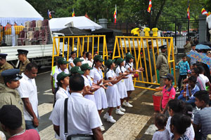 A school dance group performs beside the high yellow barriers