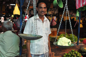 A male vendor weighs the cauliflower for us