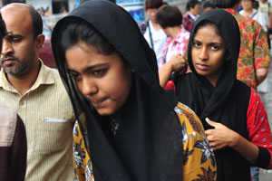 A serious girl is walking along Sri Dalada Veediya street