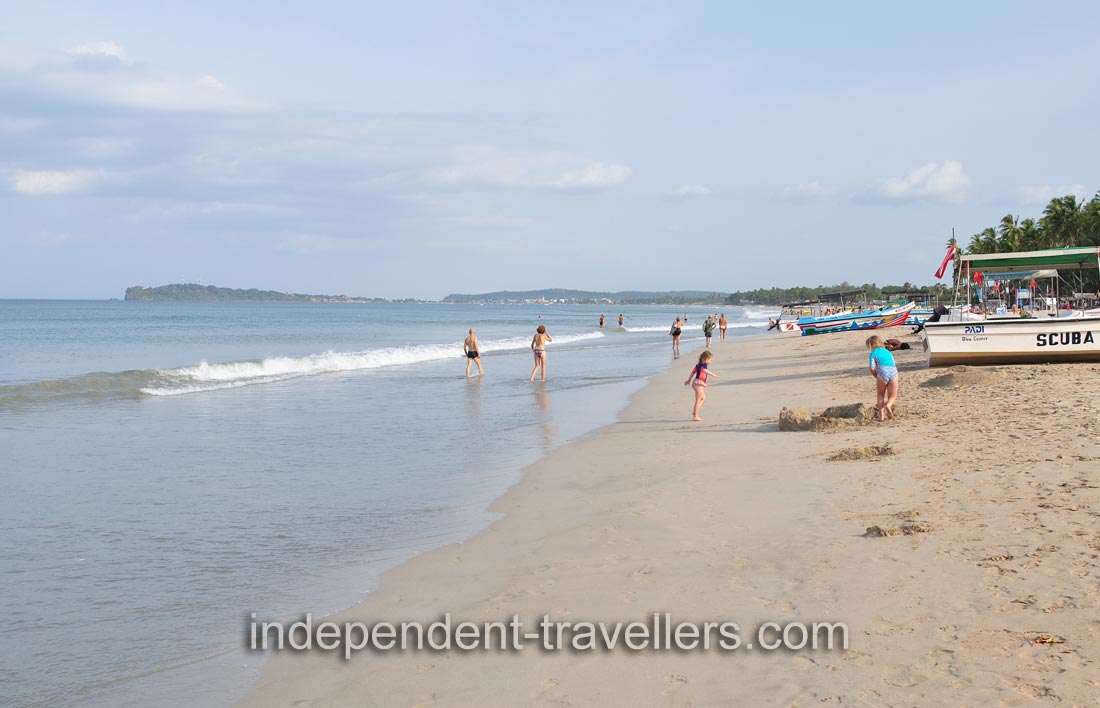 People are walking along Uppuveli beach