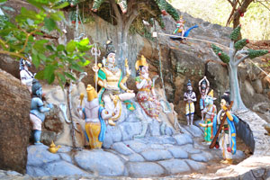 The wall of the cliff features bright religious characters