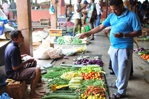 A buyer pays cash to the seller at the fruit and vegetable market