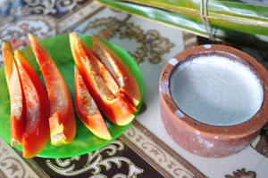 Papaya slices and a curd in a pot