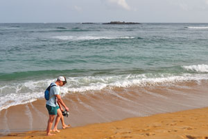 A couple of young tourists walk along the beach