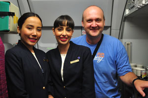 It is me with two charming flight attendants of Qatar Airways