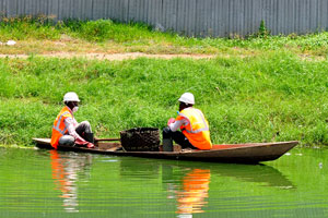 Sanitation workers do their job on the lake