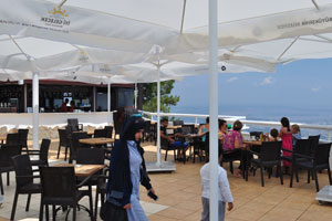 A cafe is protected form the sun with huge parasols
