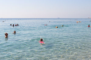 People relax in the crystal clear waters of Konyaalti Beach