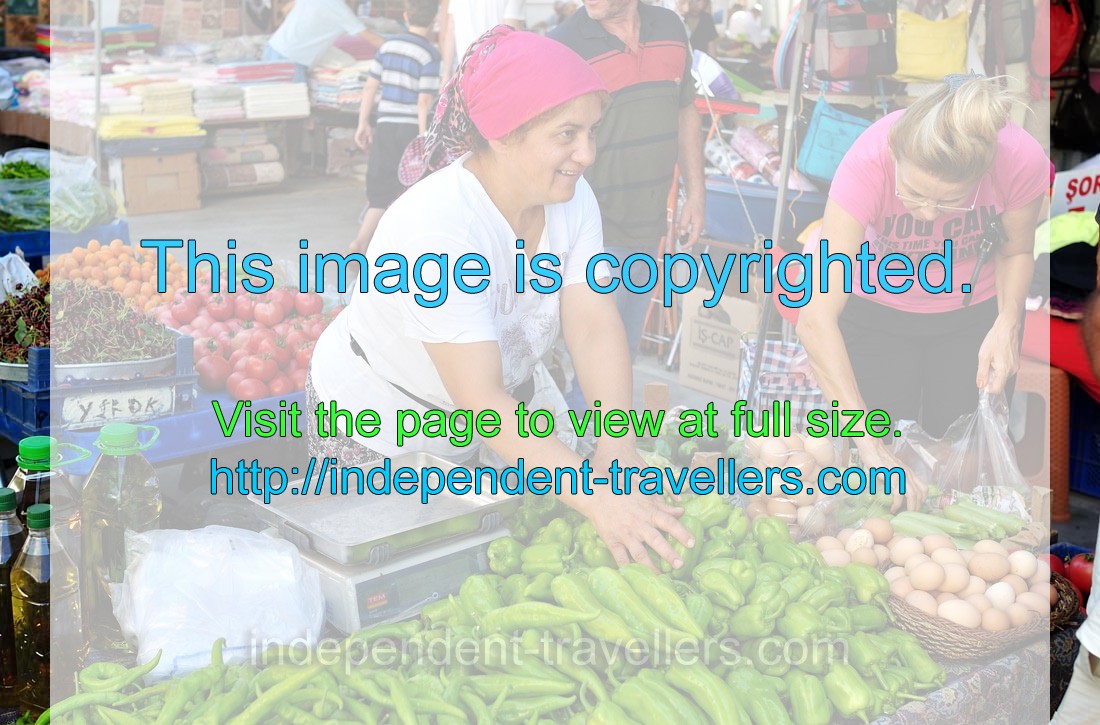 A female vendor is smiling while selling the vegetables