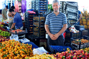 A male vendor sells apricots