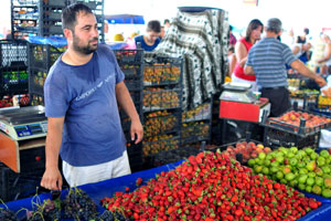 A male vendor sells strawberries