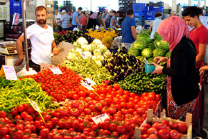 A male vendor sells vegetables