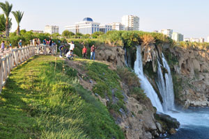 Tourists want both to take photographs and to be photographed opposite the waterfall
