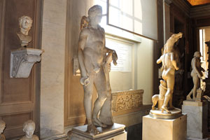 Gallery of the Candelabra: The back side of the statue of “Satyr with Dionysus as a child” is on the right