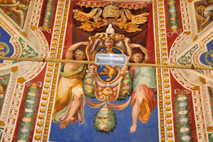 The painting of papal coat of arms with funny faces of angels is in the Vatican Apostolic Library