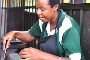 A charming Zimbabwean woman cooks Sadza in the Invuvu Bar