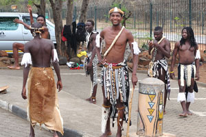 A group of local people perform in the national clothes at the parking lot