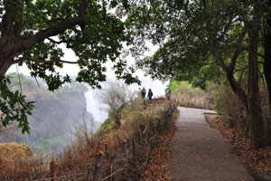 The paved footpath runs along the edge of the waterfall